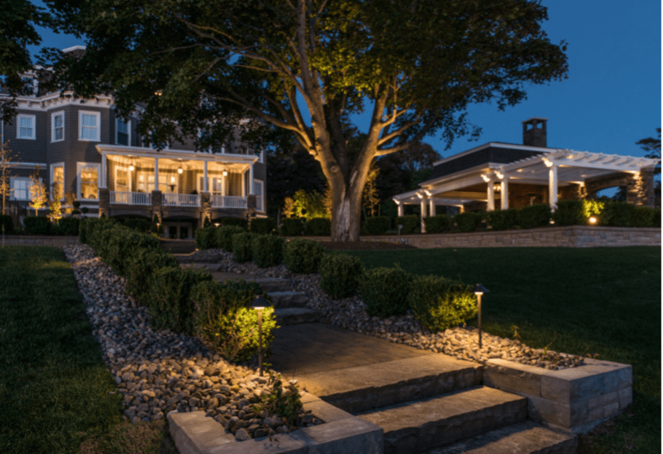 Residential landscape lighting illuminating walkway, steps, trees, and outdoor living areas at night